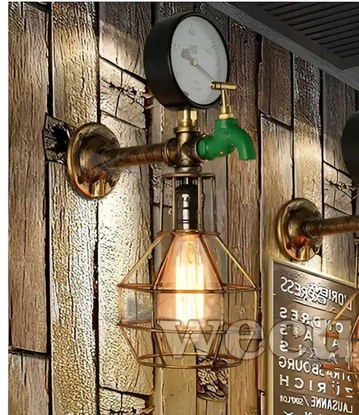 Industrial retro wall sconce with brass piping green faucet handle and amber glowing bulb in wire cage for bedroom decorbites industrial retro