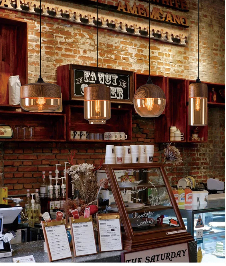 Warm-toned led pendant light with wooden tops and glass shades as a dining room light source above a coffee shop counter