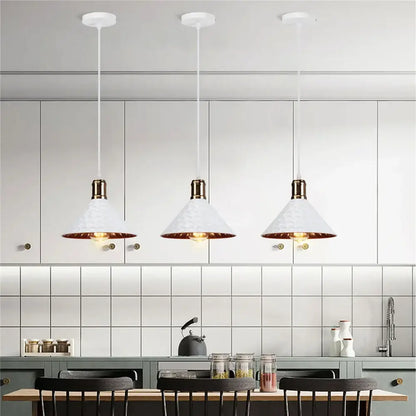 Three white industrial retro pendant lamps with hammered copper accents hang above a kitchen counter decorbites industrial retro