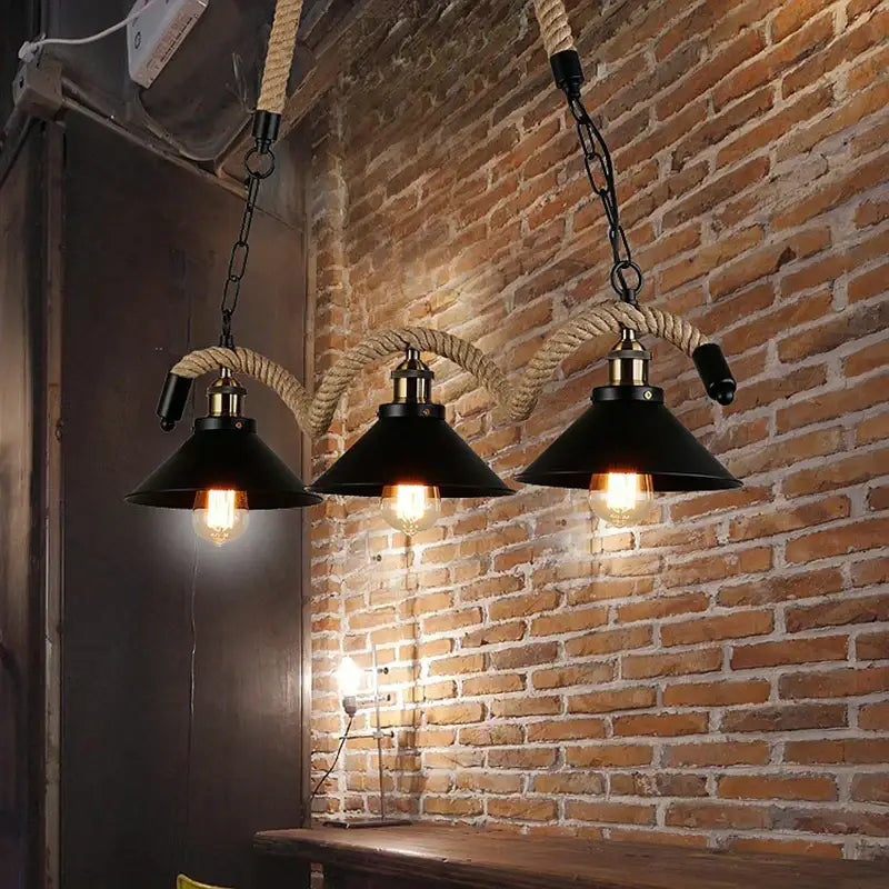 Three black industrial rustic pendant lights with brass accents and thick rope suspension for dining room decorbites industrial rustic design