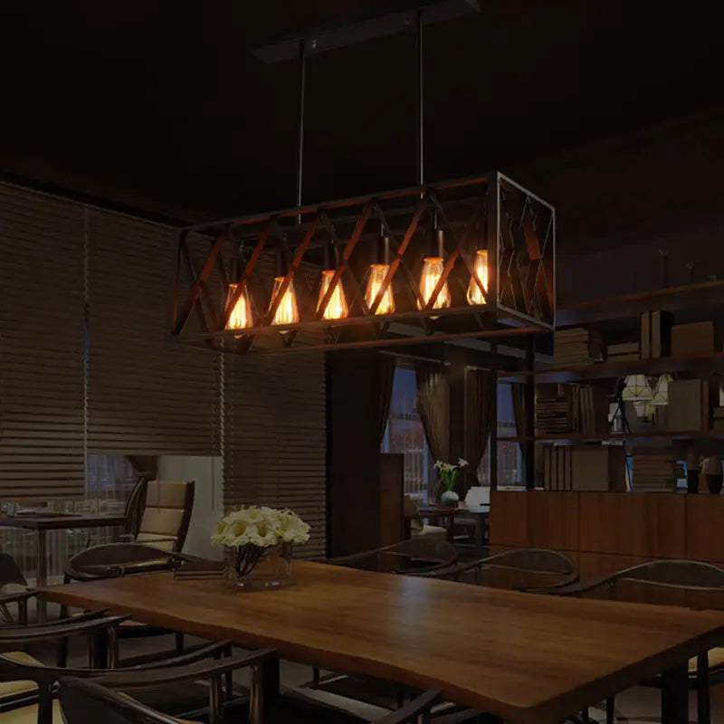 Industrial style black ironwork rectangular island light with multiple glowing filament bulbs for kitchen use