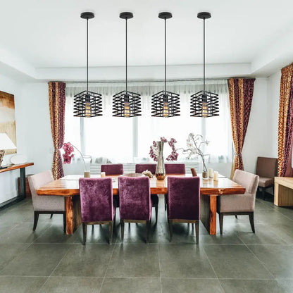 Four black metal cage pendant lights hang above a dining table in a decorbites industrial vintage led set