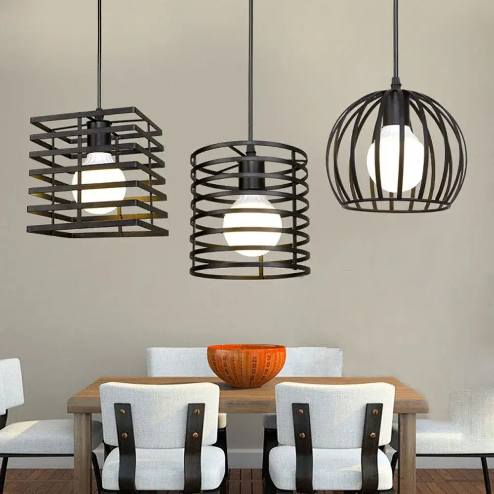 Three black metal pendant lights with cage designs hang above a dining table in a decorbites industrial vintage led set
