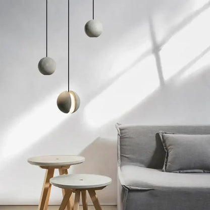 Three minimalist matte gray concrete pendant lamps with one illuminated suitable for kitchen dining decorbites industrial vintage
