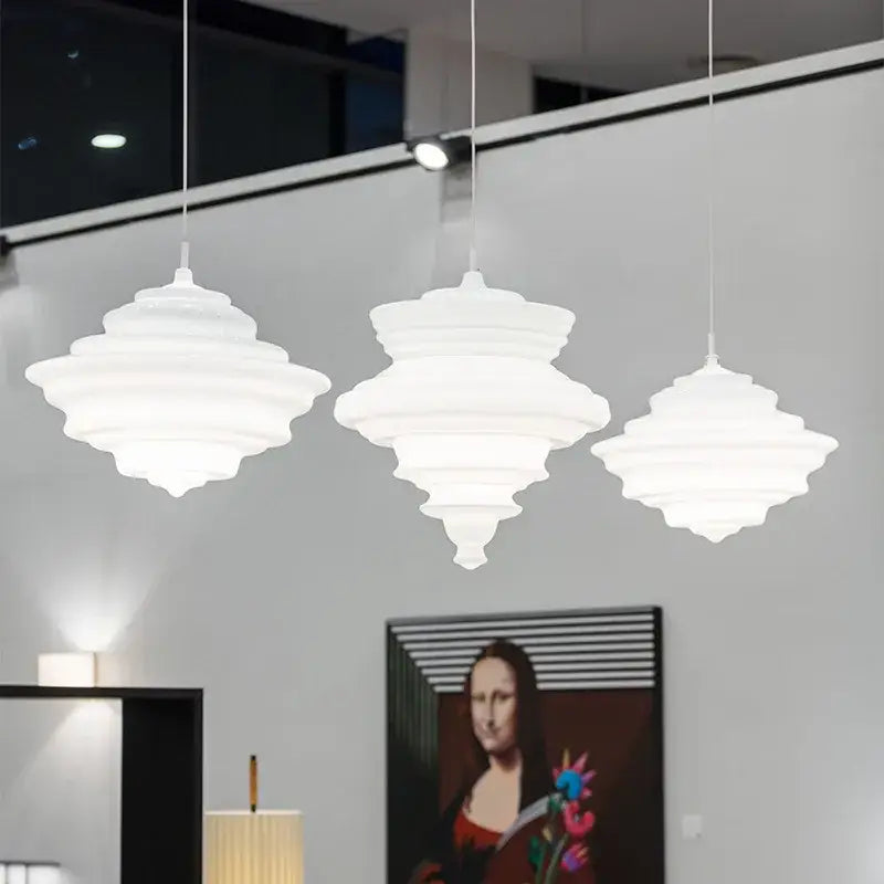 Three white tiered pendant lamps with a sculptural design for decorbites industrial vintage glass dining room decor