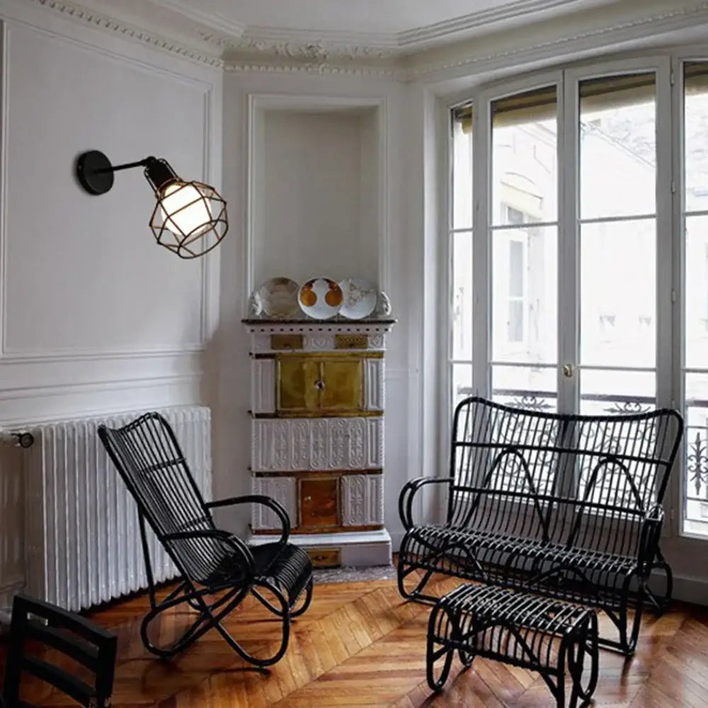 Black wicker rocking chair with curved armrests and slatted back paired with industrial vintage led wall light