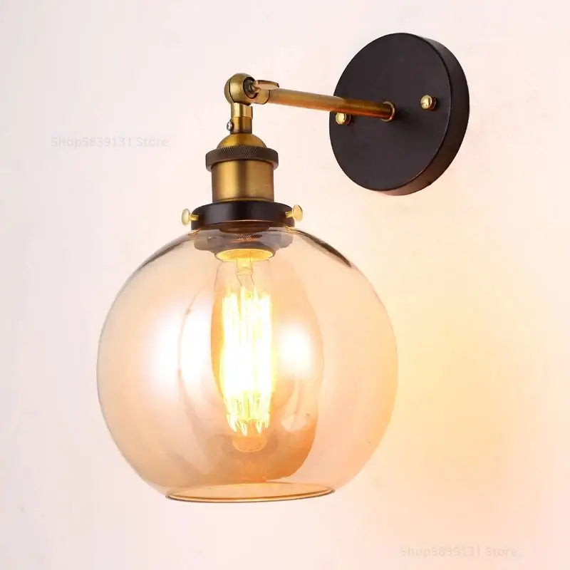 Vintage-style wall lamp with warm amber glass globe and brass-finished arm, decorbites industrial vintage loft sconce