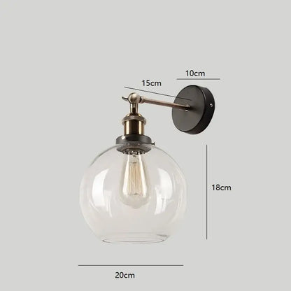 Clear glass globe wall lamp with brass-finished arm and black mount for decorbites industrial vintage loft decor