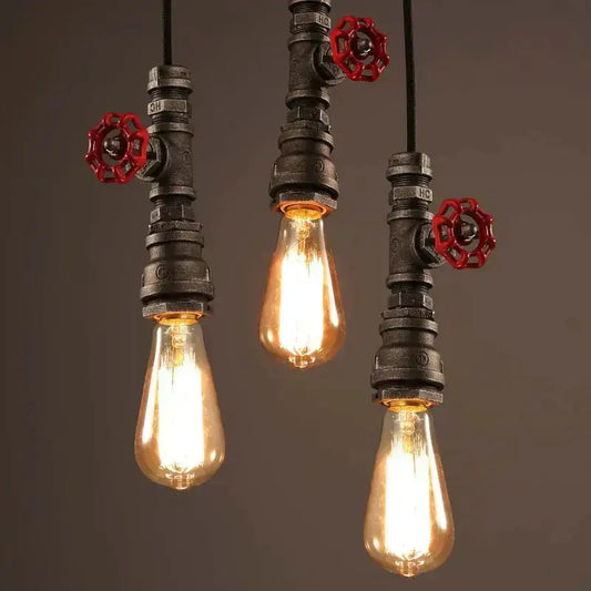 Industrial water pipe chandelier featuring black pipe fixtures and red valve handles with amber filament bulbs