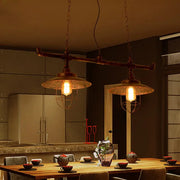 Industrial-style pendant lights with weathered copper pipe design and metal cage shades hanging by chain cord length
