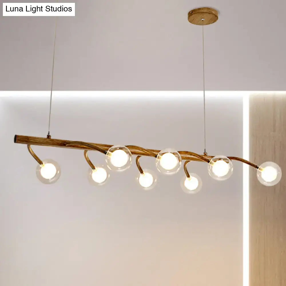 Rustic golden-brown wooden branch pendant light with modo clear glass shade for dining hall or island lighting