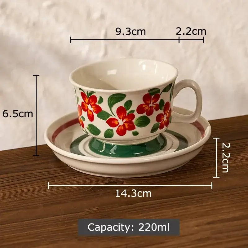 A white ceramic ink flowers ceramic teacup and saucer set with red floral pattern and green leaves for dining room decorbites