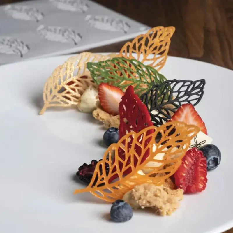 Delicate multi-colored leaf-shaped chocolate garnishes made with light blue silicone mold for decorbites coral branch leaf designs