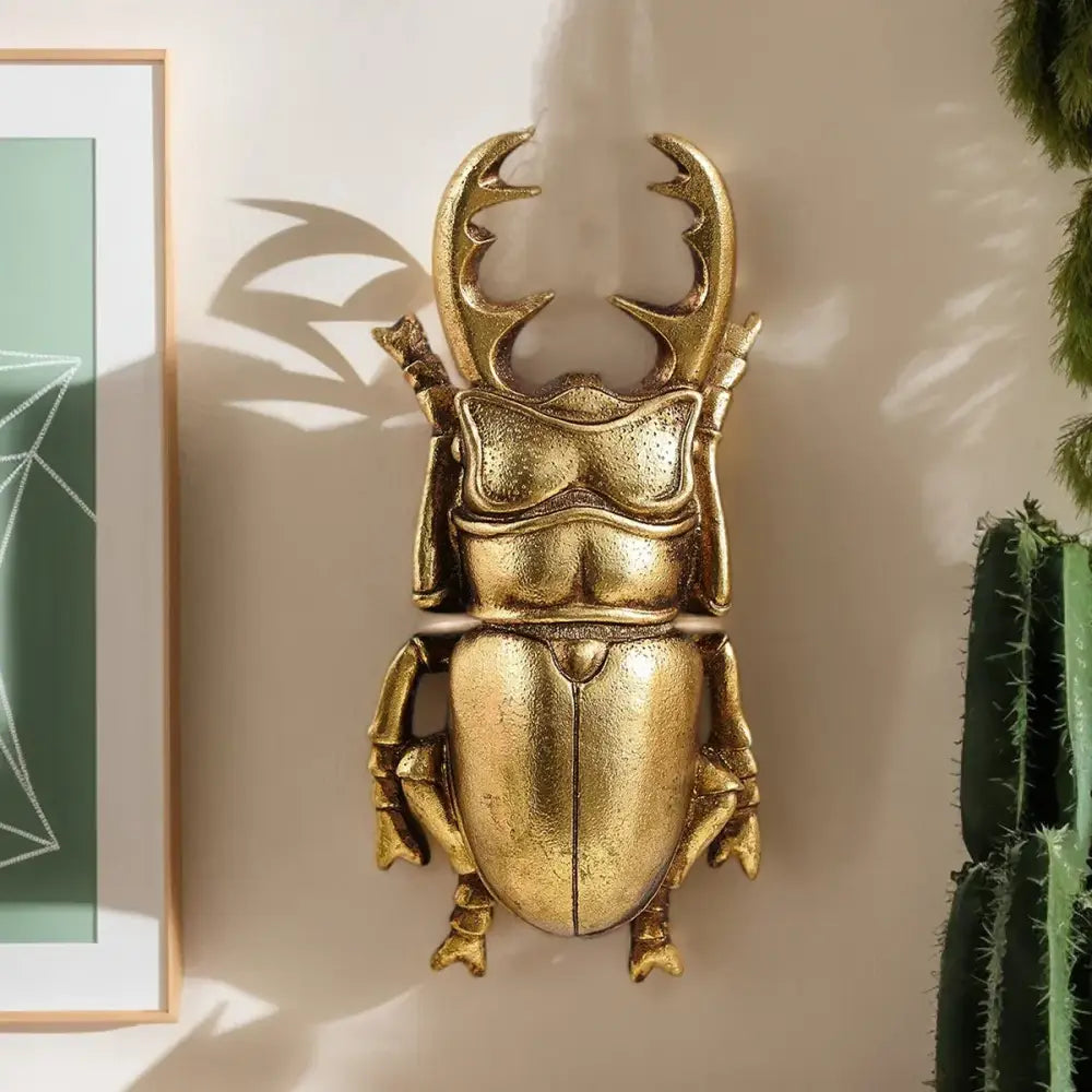 Intricate golden beetle resin wall decor featuring a polished metallic finish and detailed sculpted stag beetle design for living room