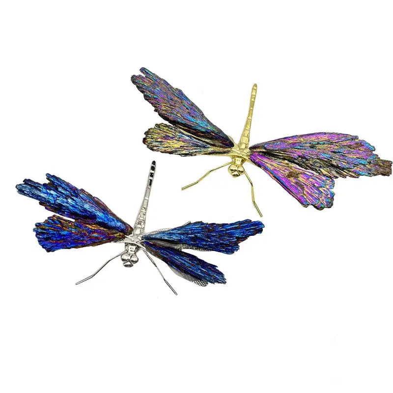 Two iridescent decorative figurines featuring crystal dragonfly designs with gold and silver bodies in blue and purple hues