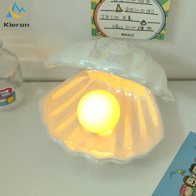 Iridescent ceramic shell pearl led night light with a glowing yellow orb for bedroom use
