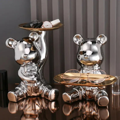 Shiny chrome decorbites colorful bear storage box with gold-trimmed trays holding accessories like watch and glasses