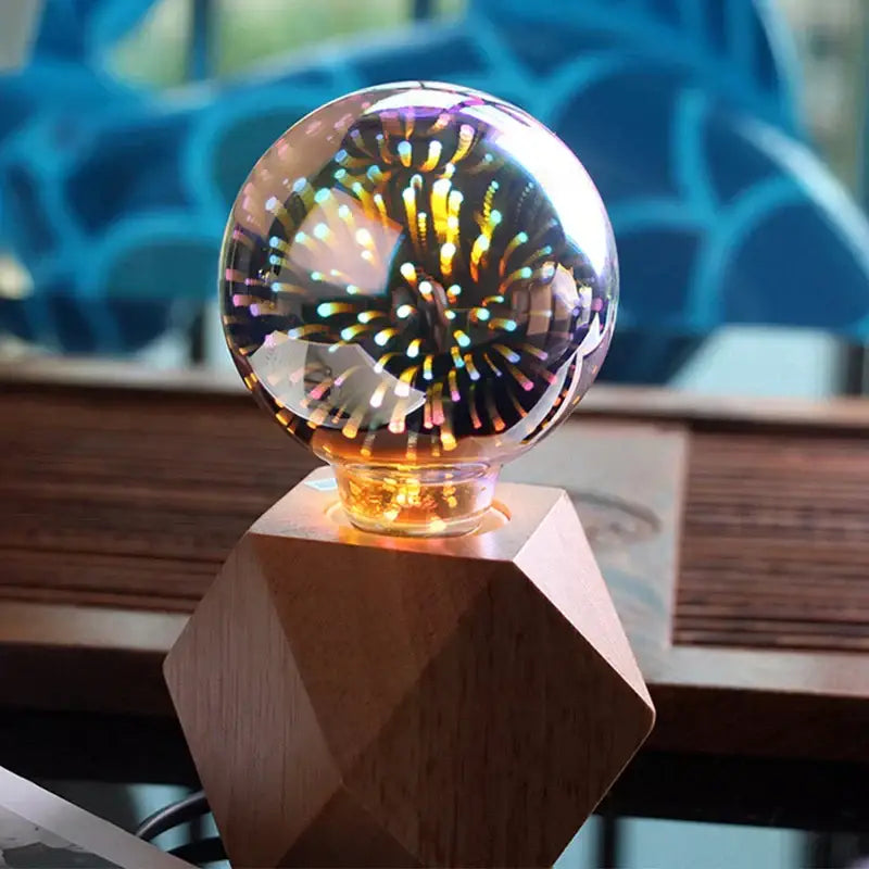 A clear glass sphere led bulb with iridescent 3d fireworks light on a geometric wooden base for bedroom decorbites decor