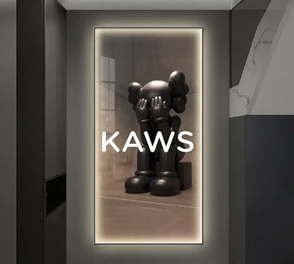 Black kaws sculpture with oversized hands covering its eyes displayed in a sleek framed mirror led wall lamp decor