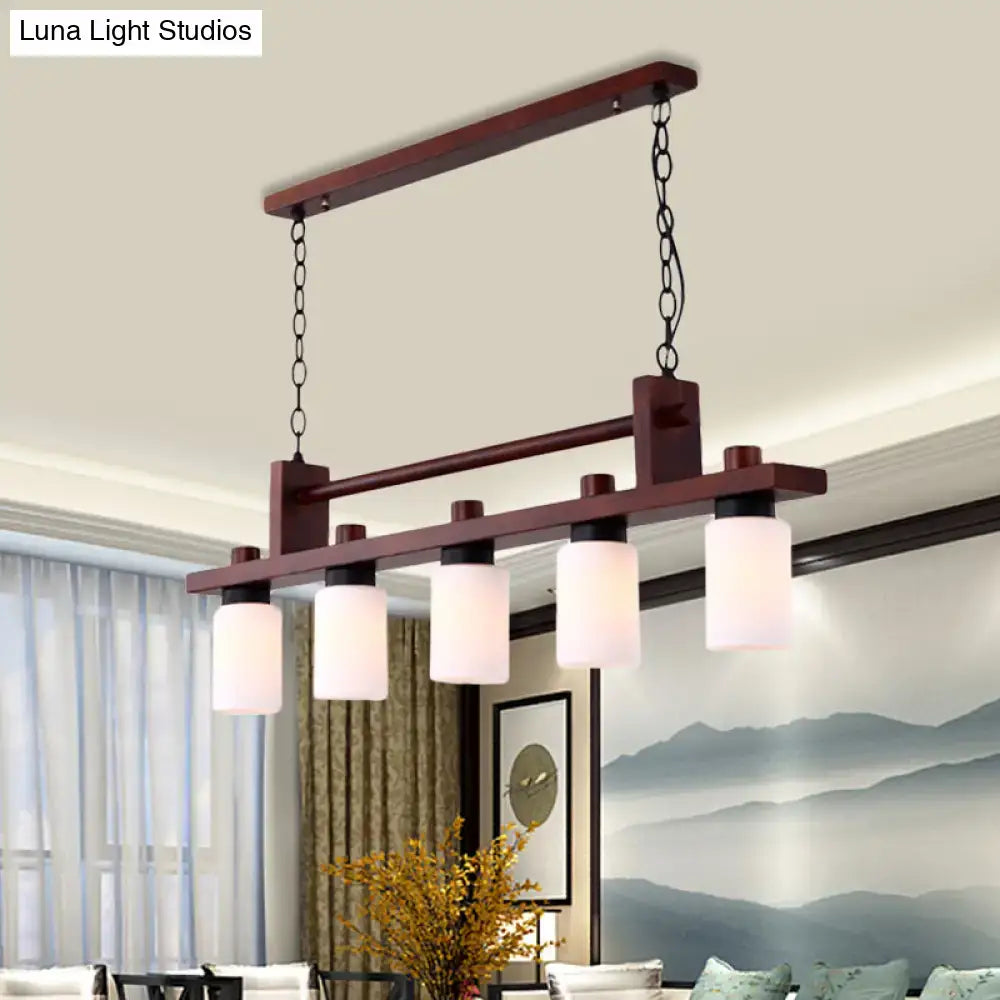 Dark wood 5-light island pendant with traditional linear wood frame and opal glass shade suspended by black chains