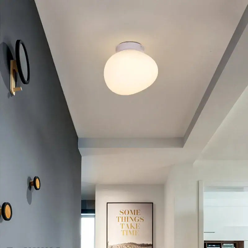 A modern italian style white bubble glass pendant lamp with frosted globe and metallic base for kitchen lighting
