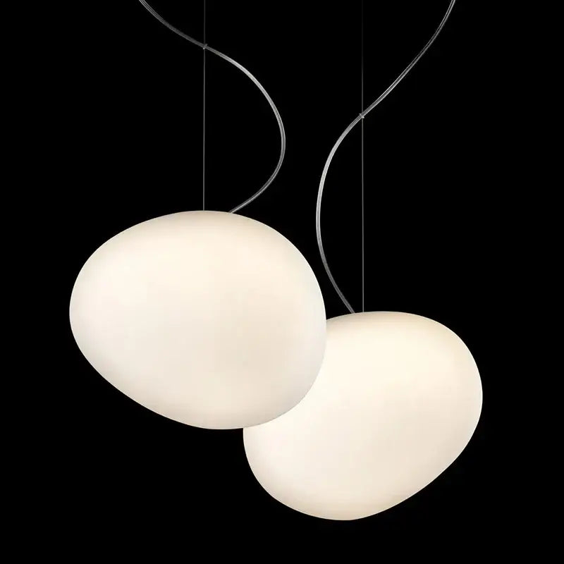 Two off-white oval-shaped italian style bubble glass pendant lamps with curved metallic cords for kitchen lighting decorbites gregg pendant lamp