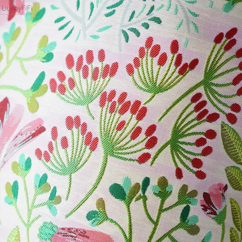 A soft pink jacquard floral pillow cover with vibrant red and green embroidered floral clusters for bedroom decor