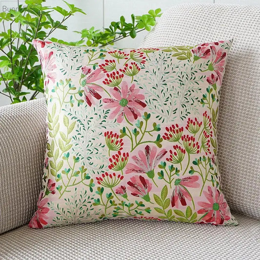 Square jacquard floral pillow cover with vibrant pink blossoms green leaves and red buds on off white background