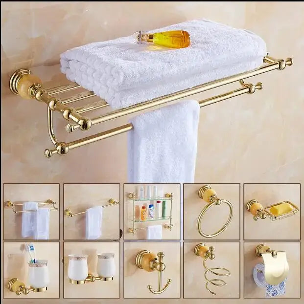 Gold-finished bathroom towel rack with polished surface and ornate spheres holding white towels in jade gold bathroom accessories set