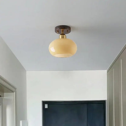 Cream-colored glass globe LED ceiling lamp with brass-finished metal base for decorbites LED ceiling lighting
