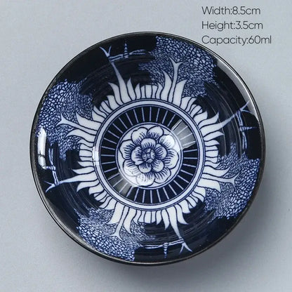 A glossy navy blue decorbites ceramic kung fu tea porcelain bowl with intricate white floral and radiating patterns