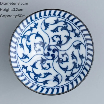 A delicate white ceramic kung fu tea cup with blue floral patterns and metallic rim for dining room use