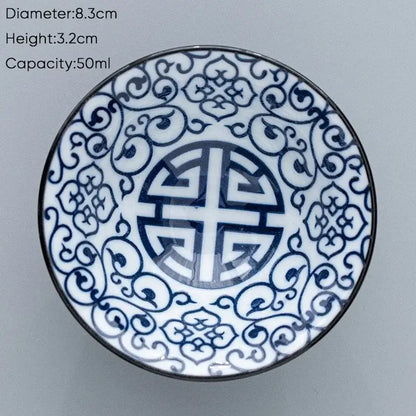 A white ceramic kung fu tea cup with intricate blue floral patterns and a central shou character design