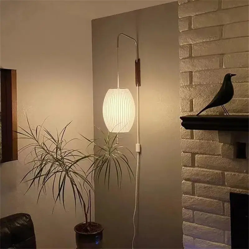 White ribbed lampshade wall light mounted on curved sconce featuring decorbites handwoven silk ball design