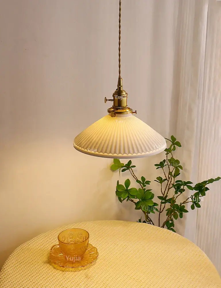 Antique brass pendant light with ribbed off-white ceramic pendant shade for kitchen and dining room use