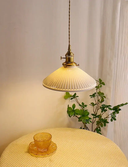 Antique brass pendant light with ribbed off-white ceramic pendant shade for kitchen and dining room use