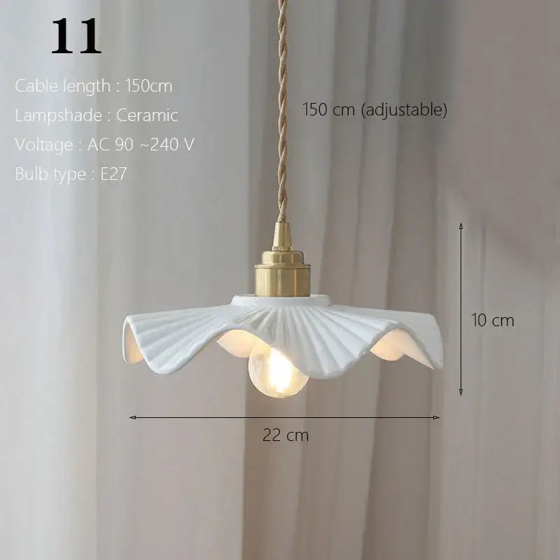 White ceramic pendant light with fluted petal design and brass hardware for kitchen and dining room use