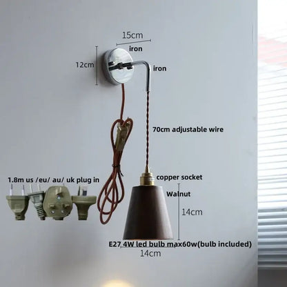 Japanese style black and brass wall lamp with pull chain features a polished iron bracket and adjustable copper socket with walnut shade