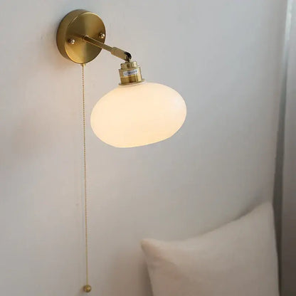 Gold-finished japanese style led brass wall sconce with frosted glass globe shade and adjustable arm by decorbites