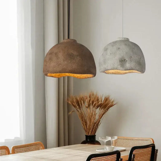 Two dome-shaped Japanese style rustic concrete resin pendant lights hang above the dining table for ambient lighting