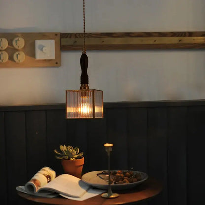A warm-toned japanese vintage brass and wood glass led pendant lamp with vertically ribbed glass panels for dining room