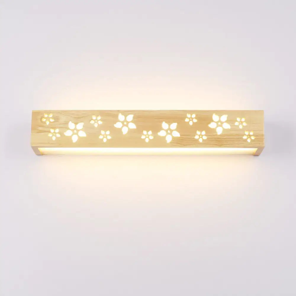 Japanese wooden floral wall lamp with natural wood finish and delicate cutouts emitting warm glow for bedroom use