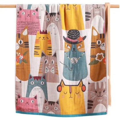 A colorful kids cute cats multicolored cotton gauze bath towel with playful cartoon cat patterns including one with a hat