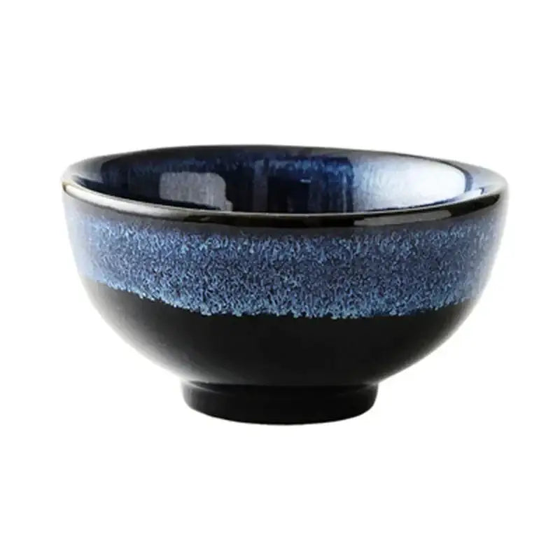 A kiln glazed ceramic bowl with a glossy black base and vibrant blue speckled glaze ideal for dining or ramen