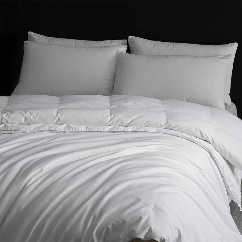 White quilted king size goose down and silk duvet set with smooth satin finish and matching pillows for master bedroom luxury