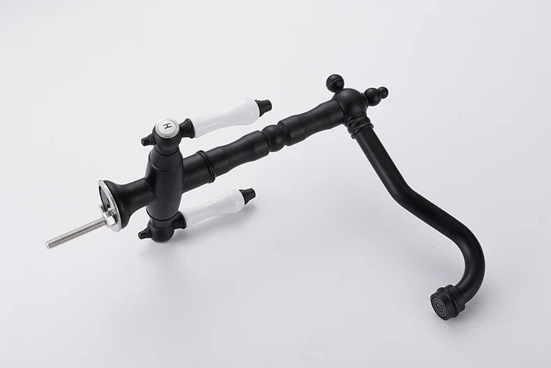 Black matte single hole kitchen faucet with white ceramic handles and curved spout made of gold brass material