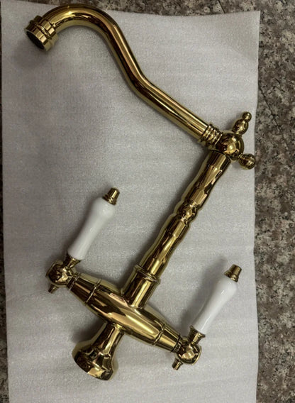 Brass kitchen faucet with white ceramic handles and vintage design for single hole installation and 360 degree swivel