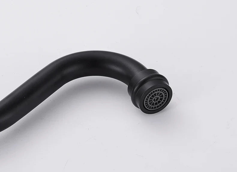 Black matte single hole kitchen faucet with curved spout and circular spray head made of gold brass for hot and cold water