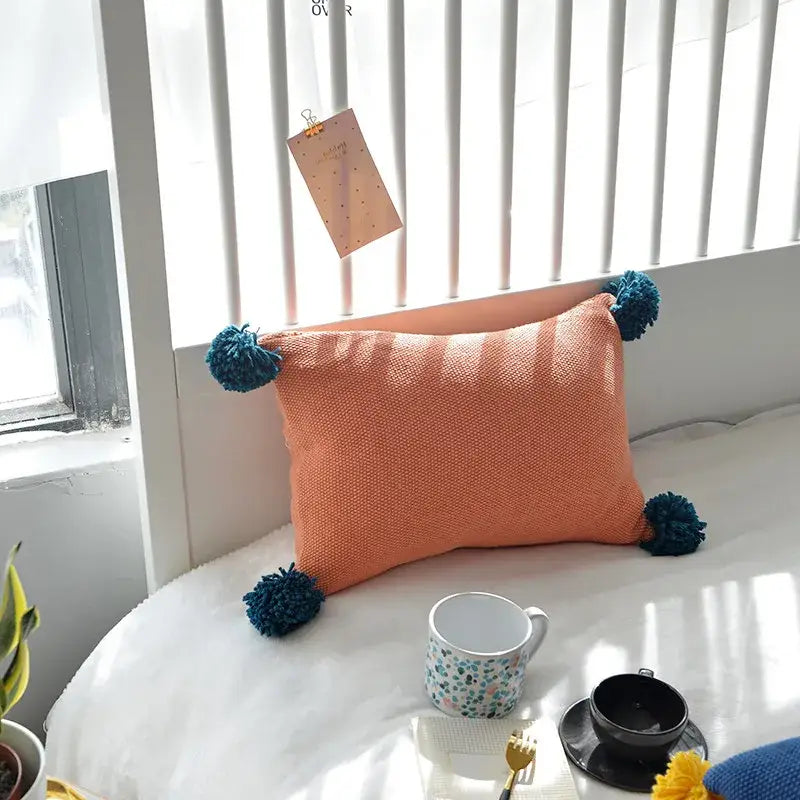 Orange textured knit cushion cover with teal pom-poms from decorbites knit cushion set for living room decor
