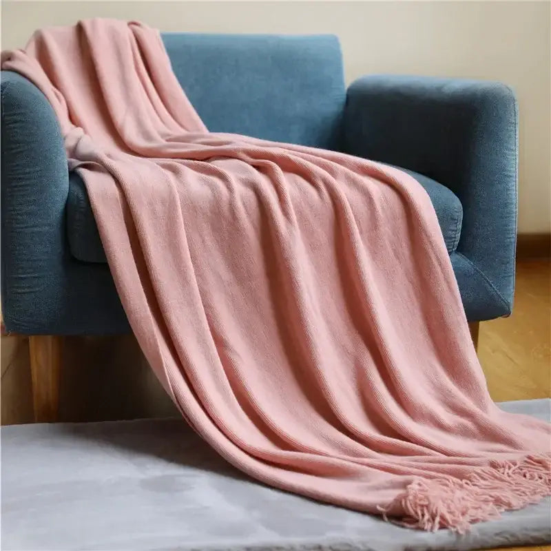 A soft dusty pink decorbites knitted cashmere siesta blanket with textured knit pattern and delicate fringe edges